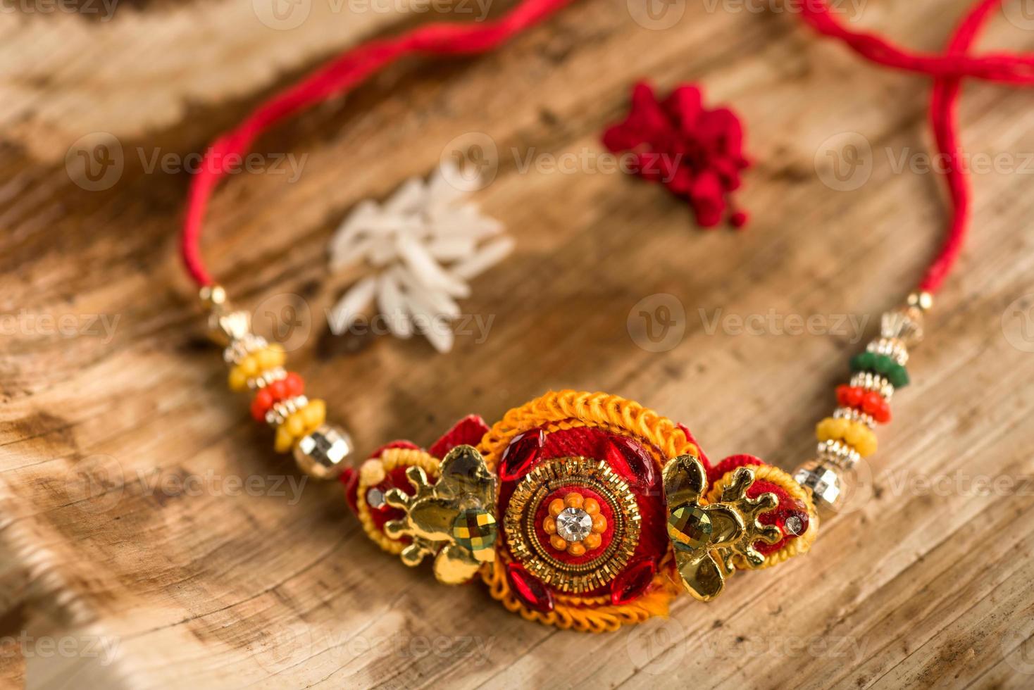 indisk festival raksha bandhan bakgrund med en elegant rakhi, riskorn och kumkum. ett traditionellt indisk armband som är en symbol för kärlek mellan bröder och systrar. foto