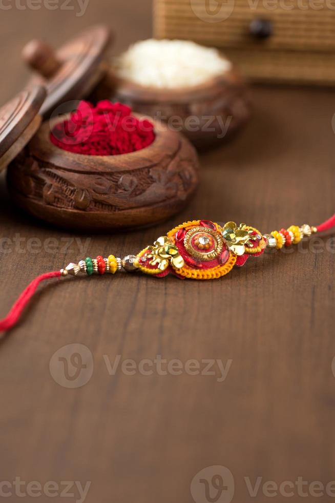 indisk festival raksha bandhan bakgrund med en elegant rakhi, riskorn och kumkum. ett traditionellt indisk armband som är en symbol för kärlek mellan bröder och systrar. foto