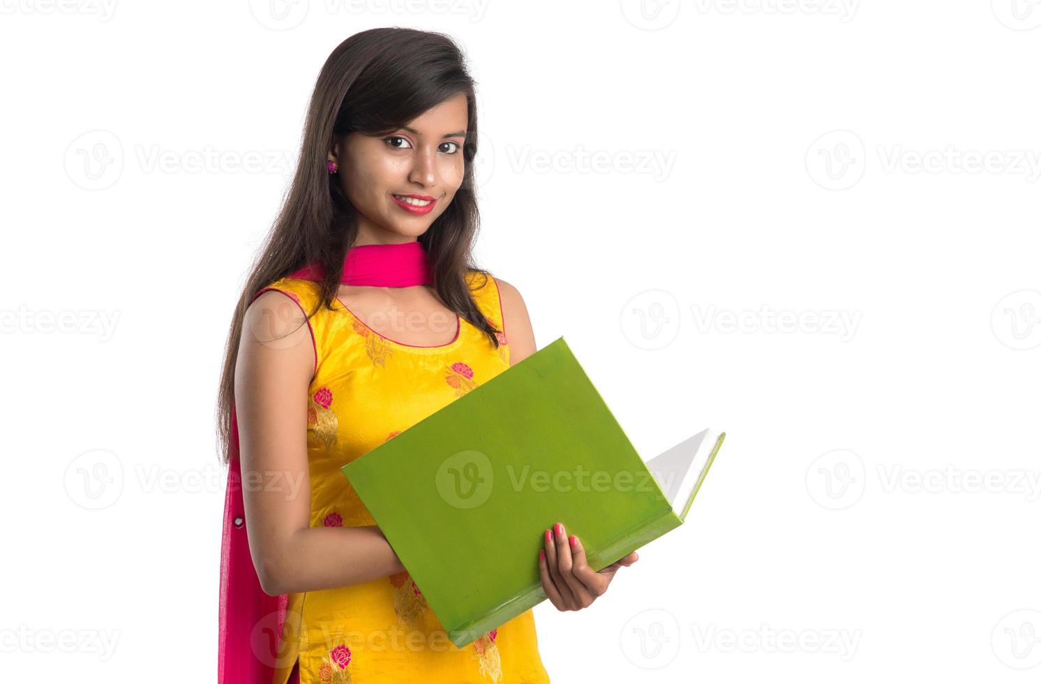 ganska ung flicka håller bok och poserar på vit bakgrund foto