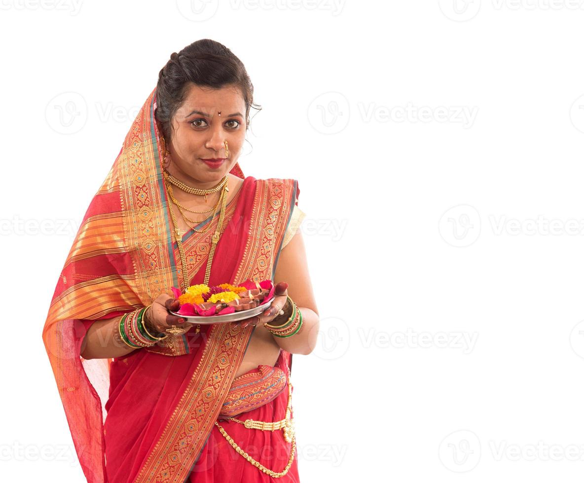 porträtt av en indisk traditionell flicka som håller pooja thali med diya under festival av ljus på vit bakgrund. diwali eller deepavali foto