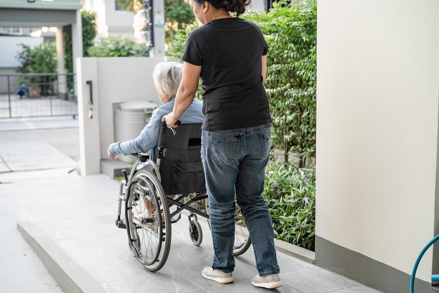 vårdgivare hjälp och vård asiatisk senior eller äldre gammal dam kvinna patient sitter i rullstol på rampen på vårdsjukhuset, hälsosamt starkt medicinskt koncept foto