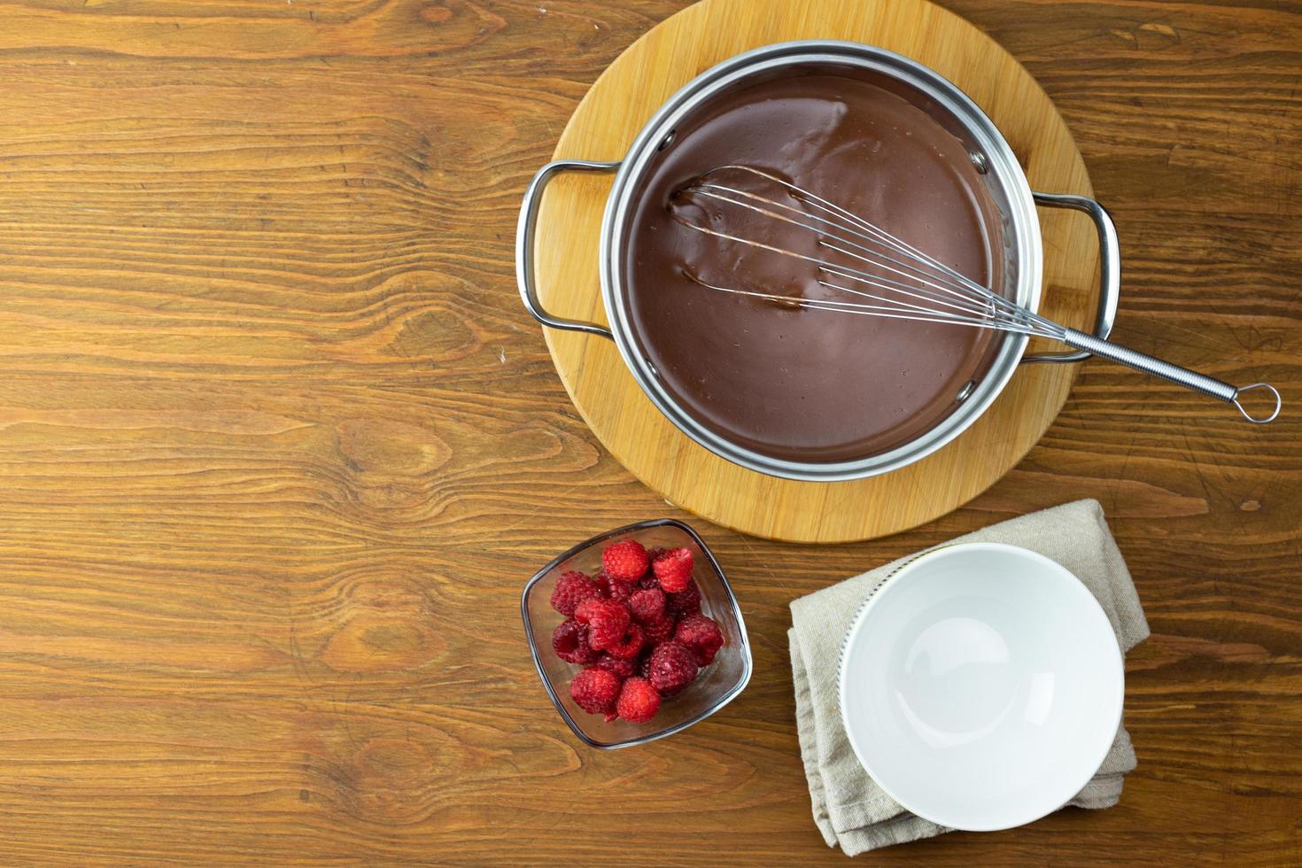 chokladpudding med hallon på ett träbord. foto