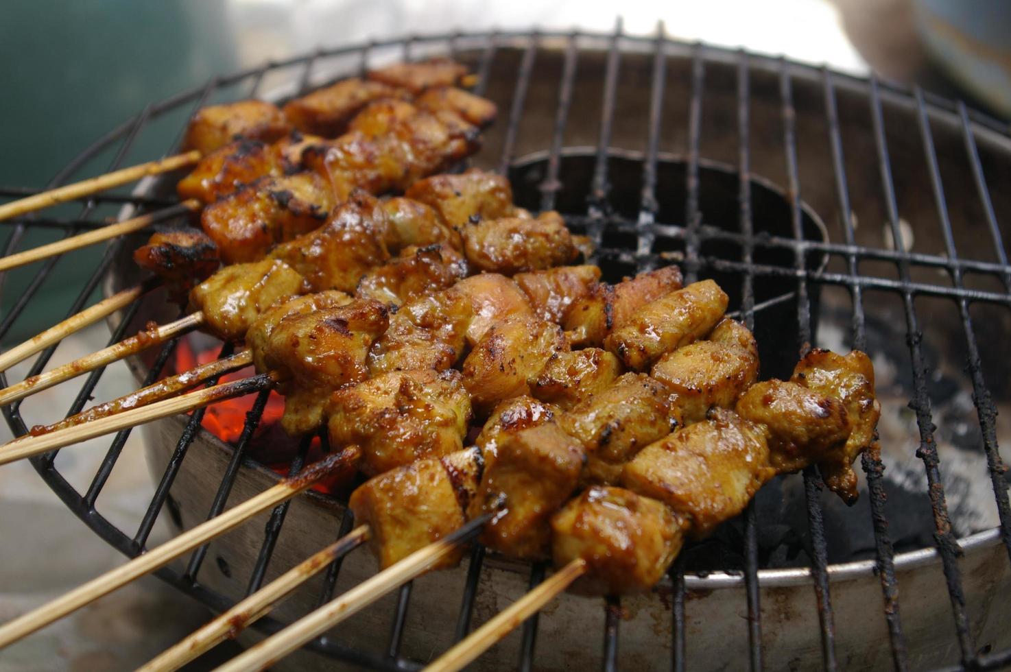 sate eller satay är en av de typiska indonesiska matarna. denna mat är gjord av kyckling, nötkött eller fårkött, tillagningsmetoden grillas över kol, kryddas med jordnötssås och sojasås. foto