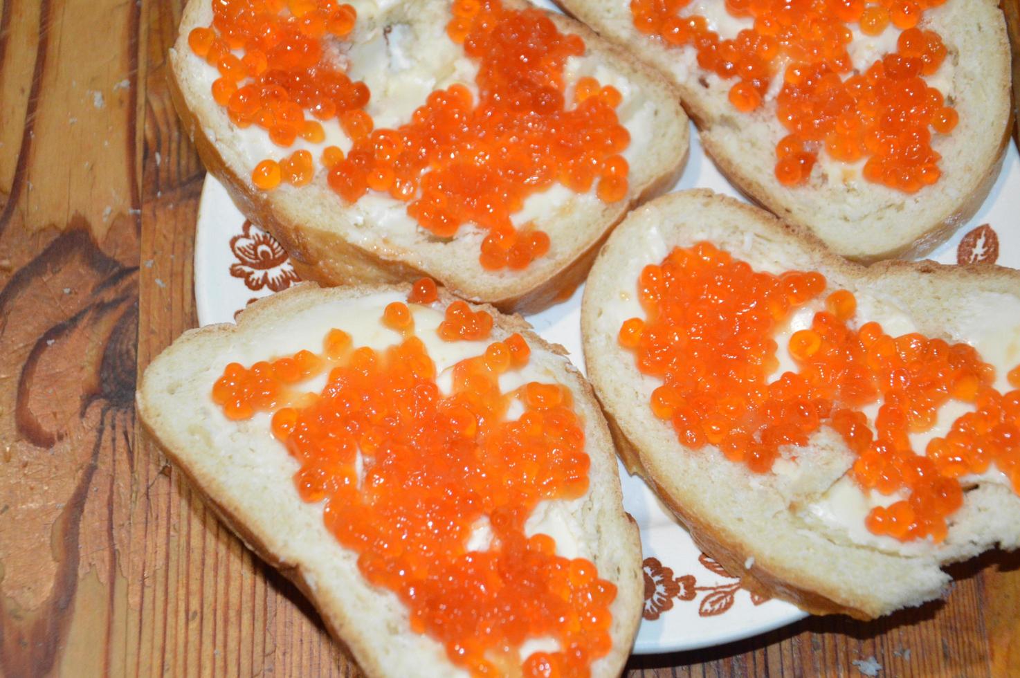 röd kaviar bred på vitt bröd och smörmackor foto