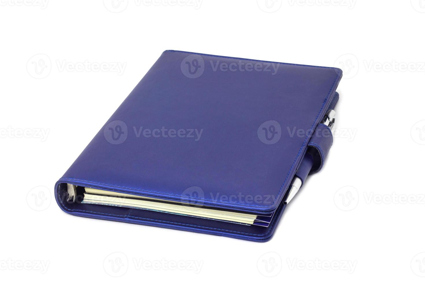 blåkragedagbok och penna placerad på omslaget och vit bakgrund. foto