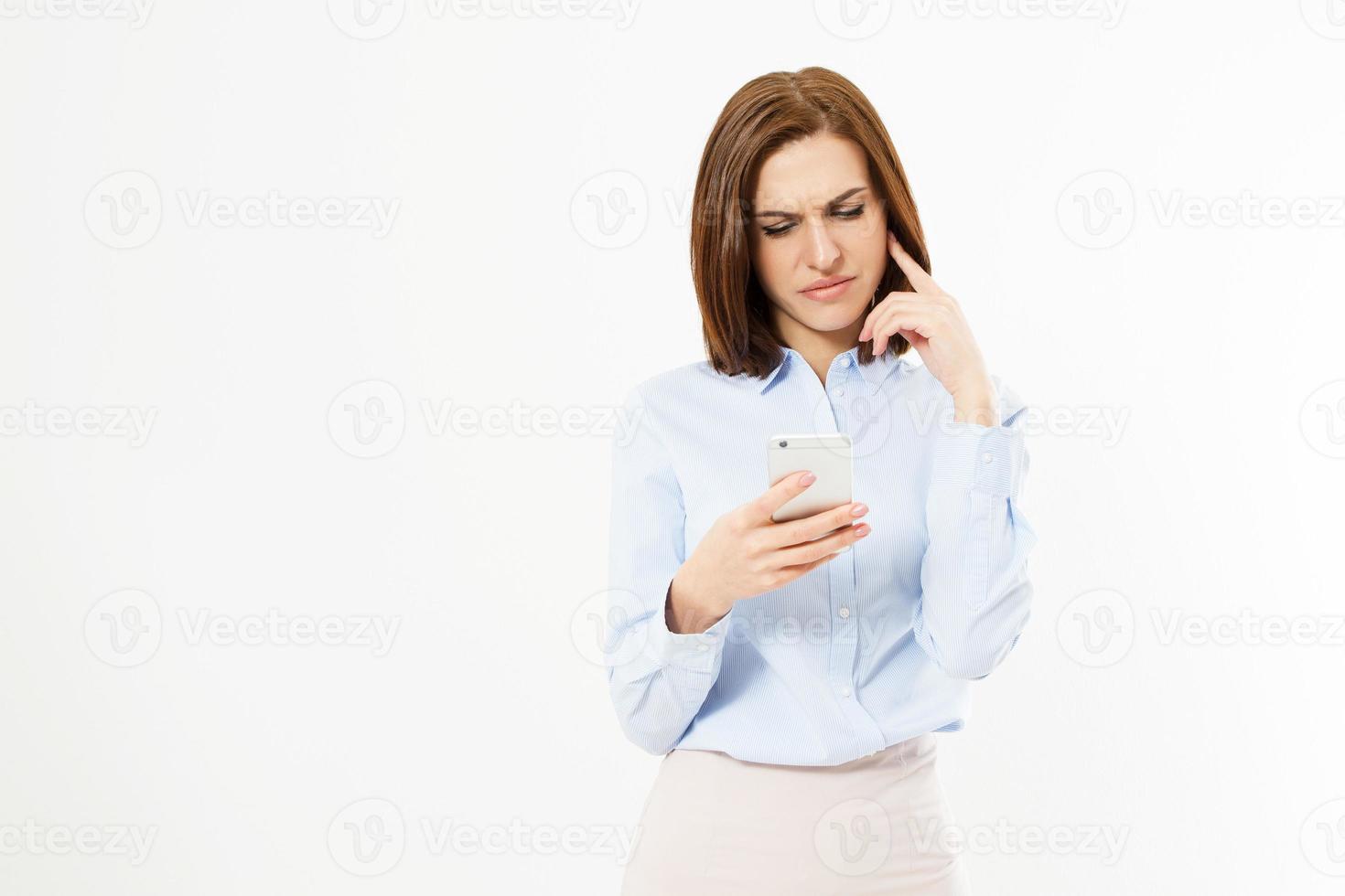 upprörd kvinna som håller en mobiltelefon. arg ung affärskvinna som läser dåliga nyheter på sin mobiltelefon. isolerad på vit bakgrund. foto