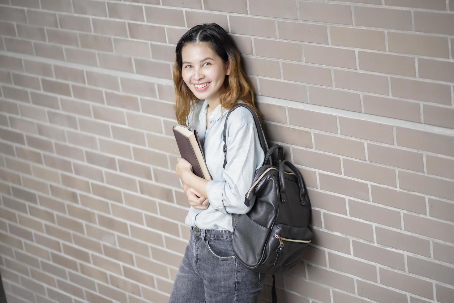 glad ung asiatisk universitetsstudent. foto