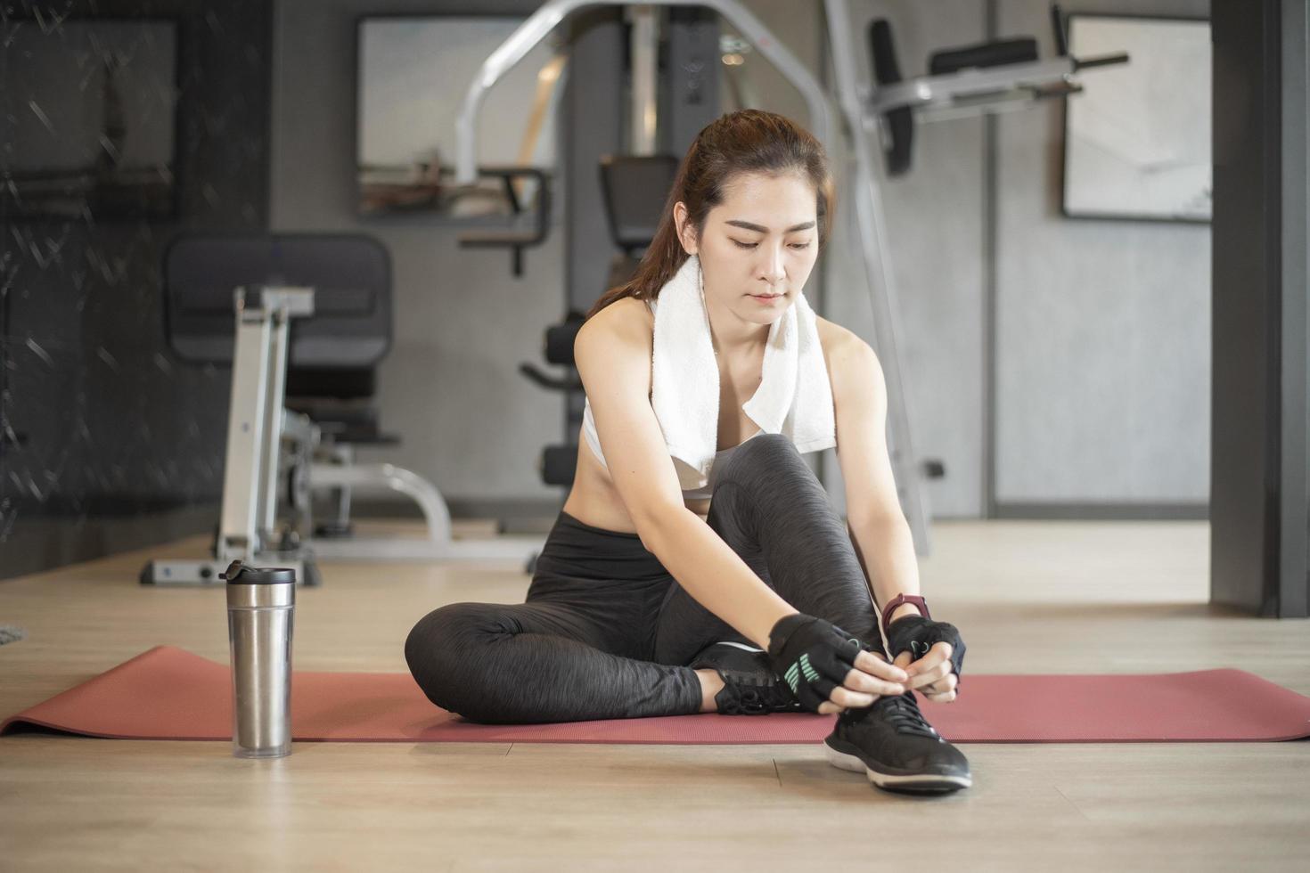 vacker asiatisk kvinna tränar i gymmet foto