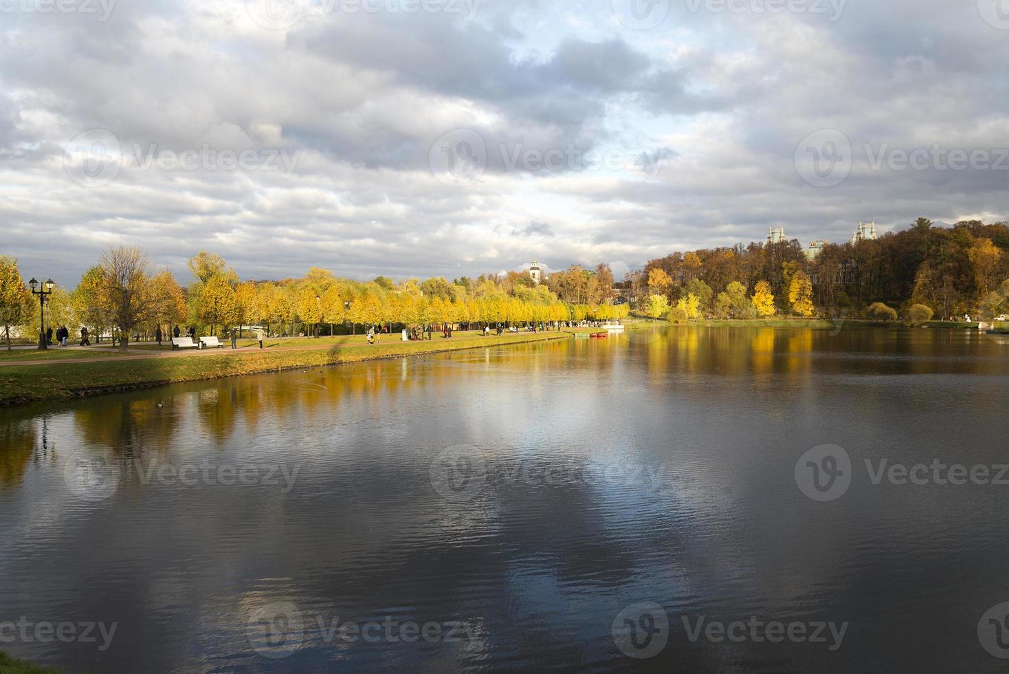 höstdag i parken med reflektion av träd på vatten. foto