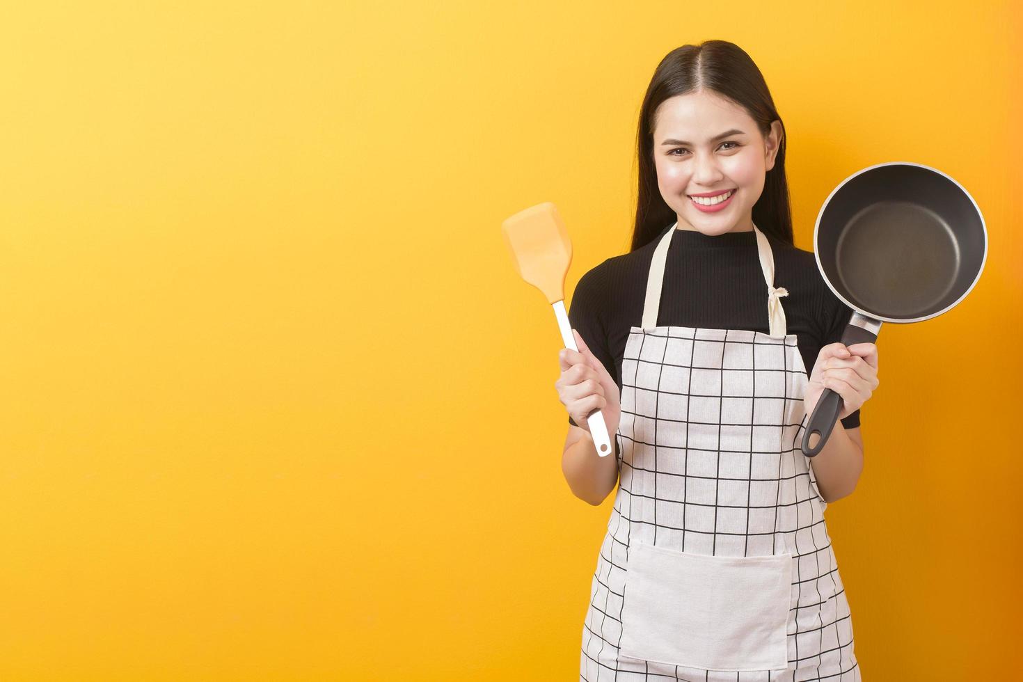 glad kvinnlig kock porträtt på gul bakgrund foto