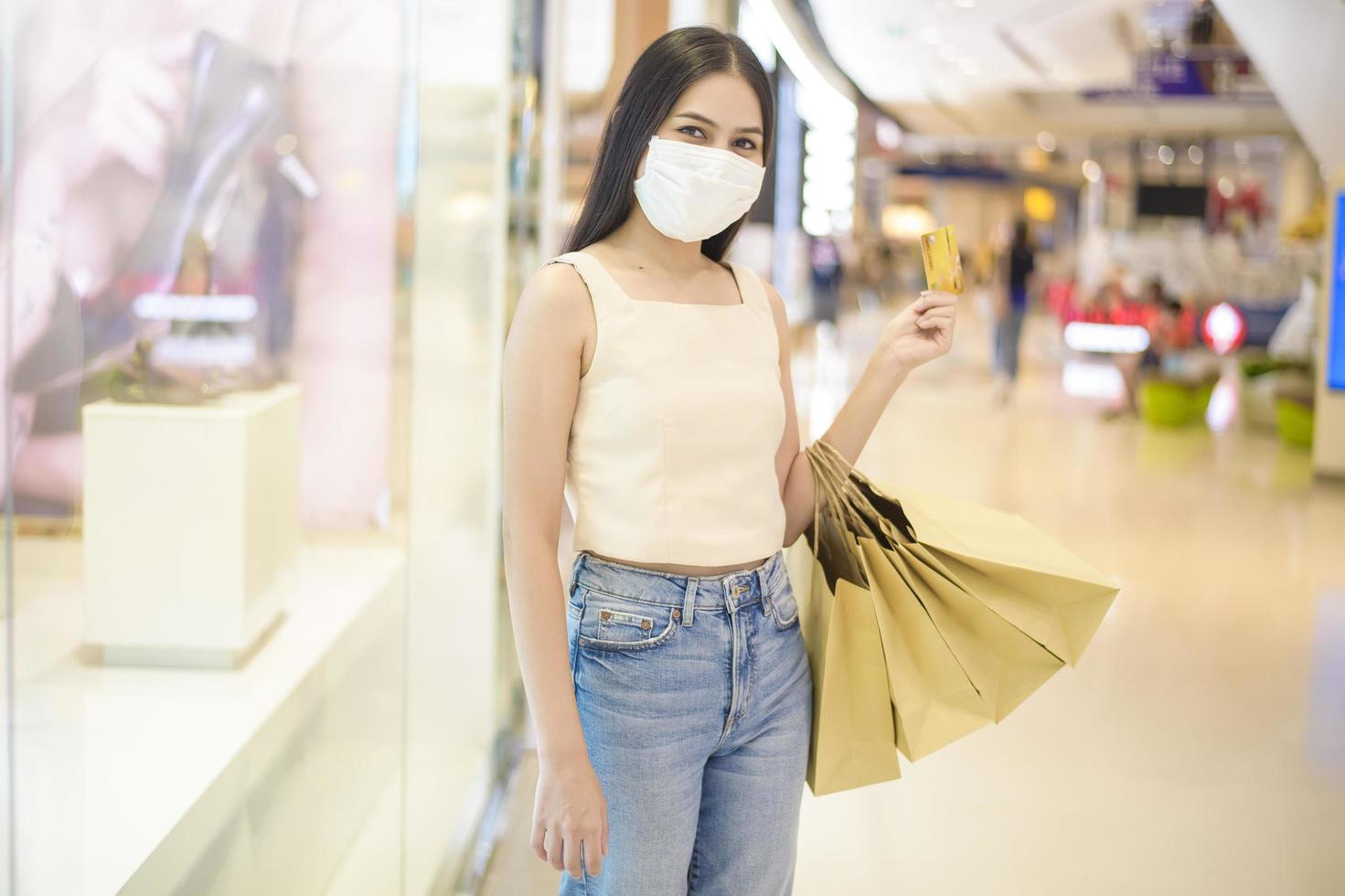 porträtt av vacker kvinna bär ansiktsmask i köpcentrum foto