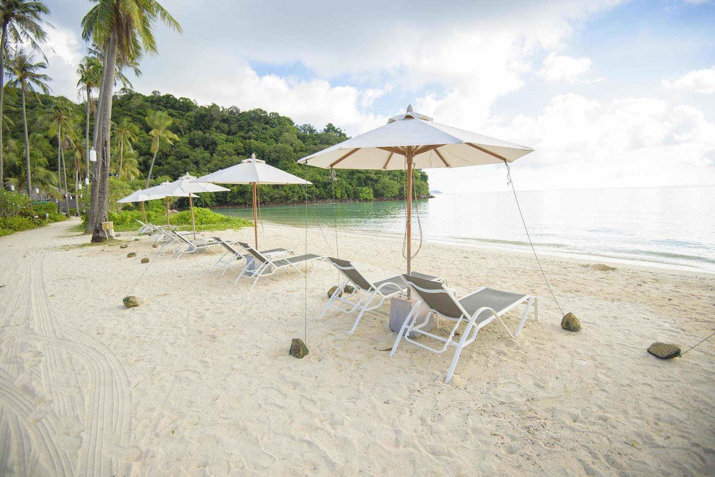 vacker utsikt landskap av solstolar på tropisk strand, smaragdhavet och vit sand mot blå himmel, Maya Bay i phi phi island, thailand foto