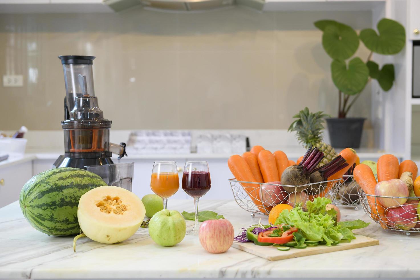 hälsosam färsk frukt, grönsaker och juicer är på bordet i köket redo att förberedas, hälsokoncept foto