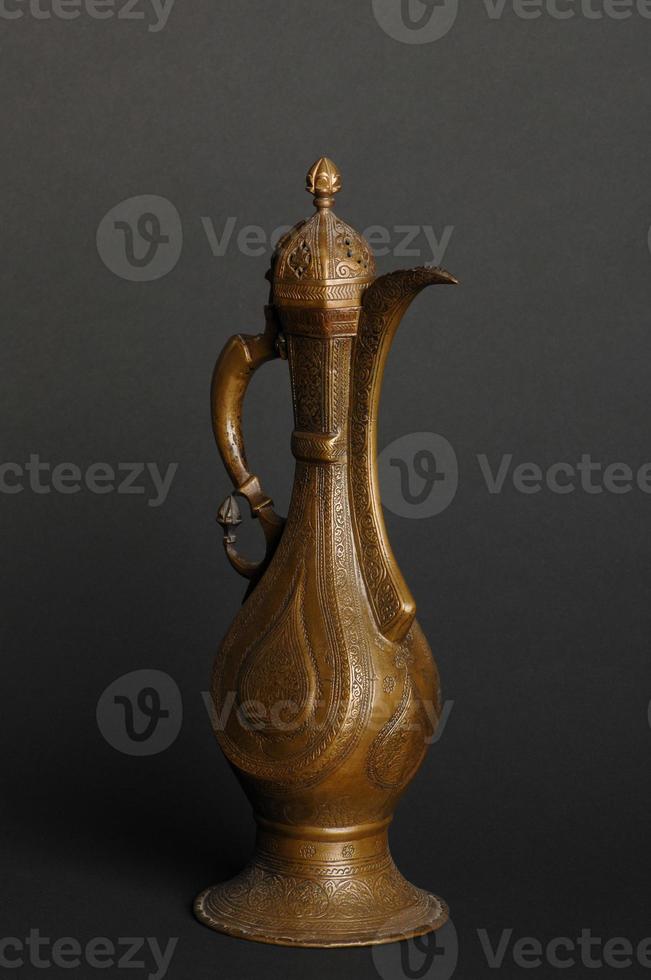 antik orientalisk metall tekanna på mörk bakgrund. antik brons servis foto