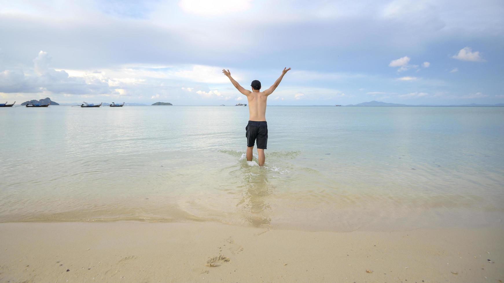 glad man njuter och kopplar av på stranden, sommar och semester koncept foto