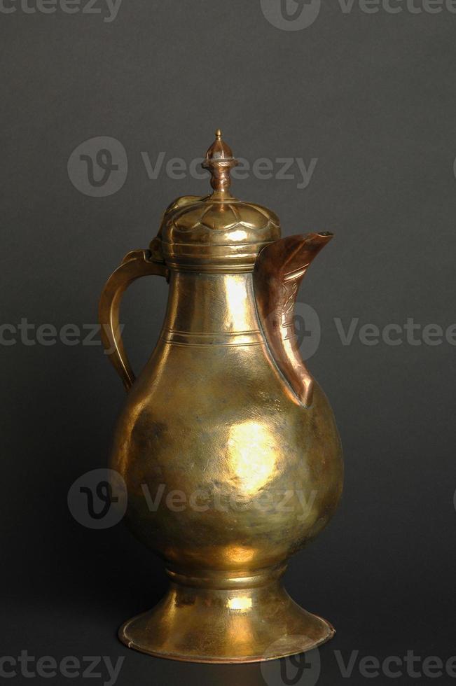 antik orientalisk metall tekanna på mörk bakgrund. antik brons servis foto