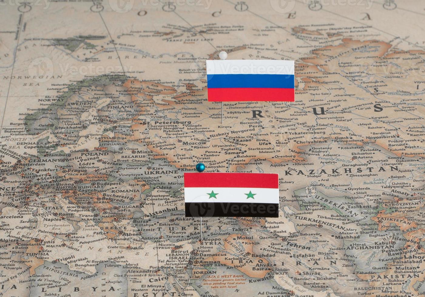 Rysslands och Syriens flaggor på världskartan. konceptuellt foto, politik och världsordning foto