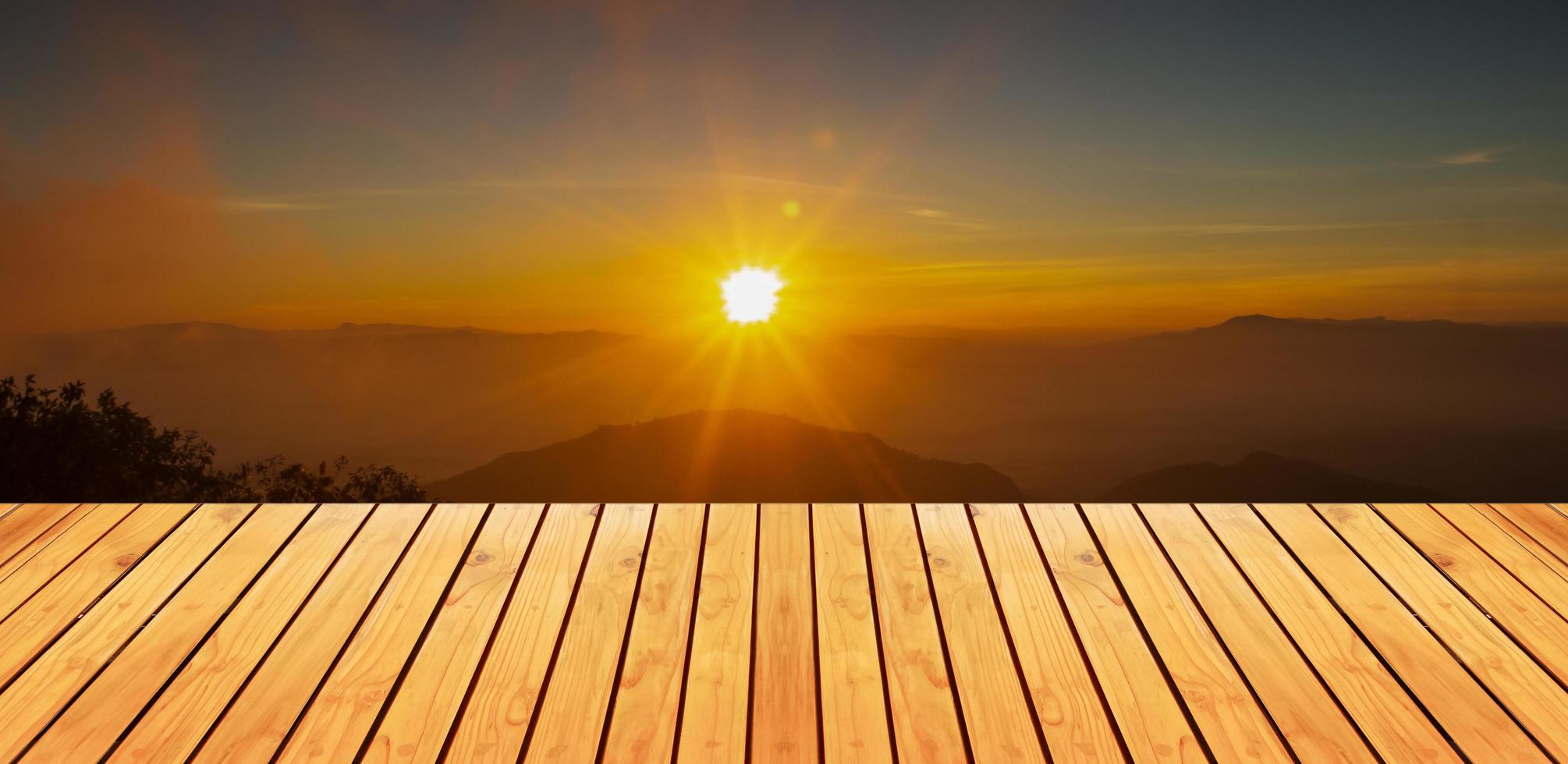 naturligt trägolv och solnedgång över bergen foto