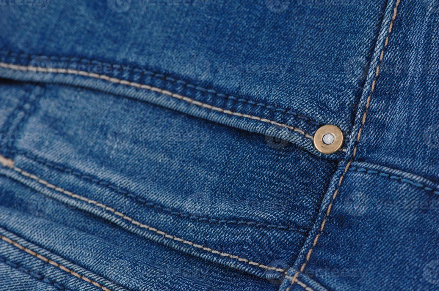 del av blå jeansbyxor med fickor och nitar, närbild foto