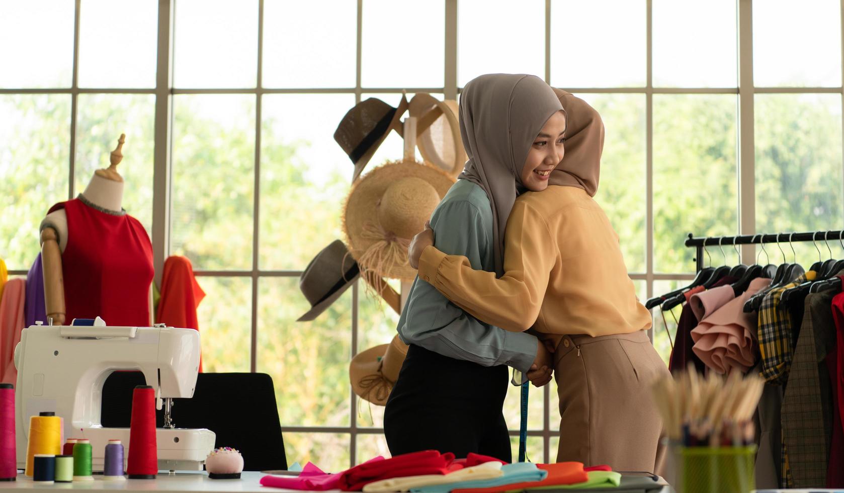 båda muslimska kvinnorna driver ett litet företag i sina egna hem. är design och skräddarsydda kläder. foto