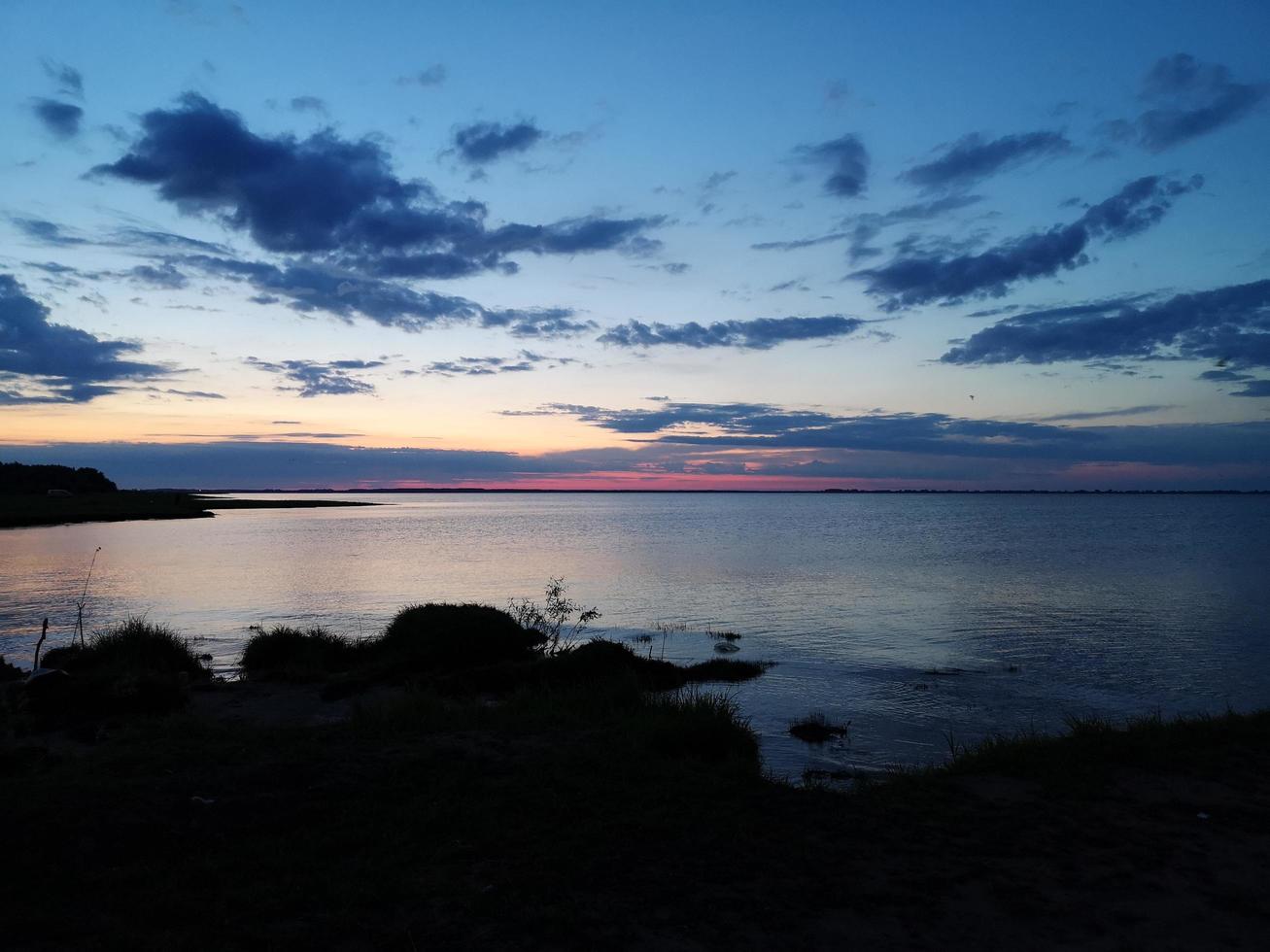 kvällshimlen vid solnedgången på en sjö eller flod. rött är en vacker ordning. vackra moln foto