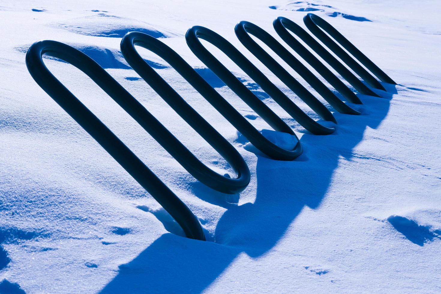 abstrakt vågigt objekt med hårda blå skuggor täckta med snö foto