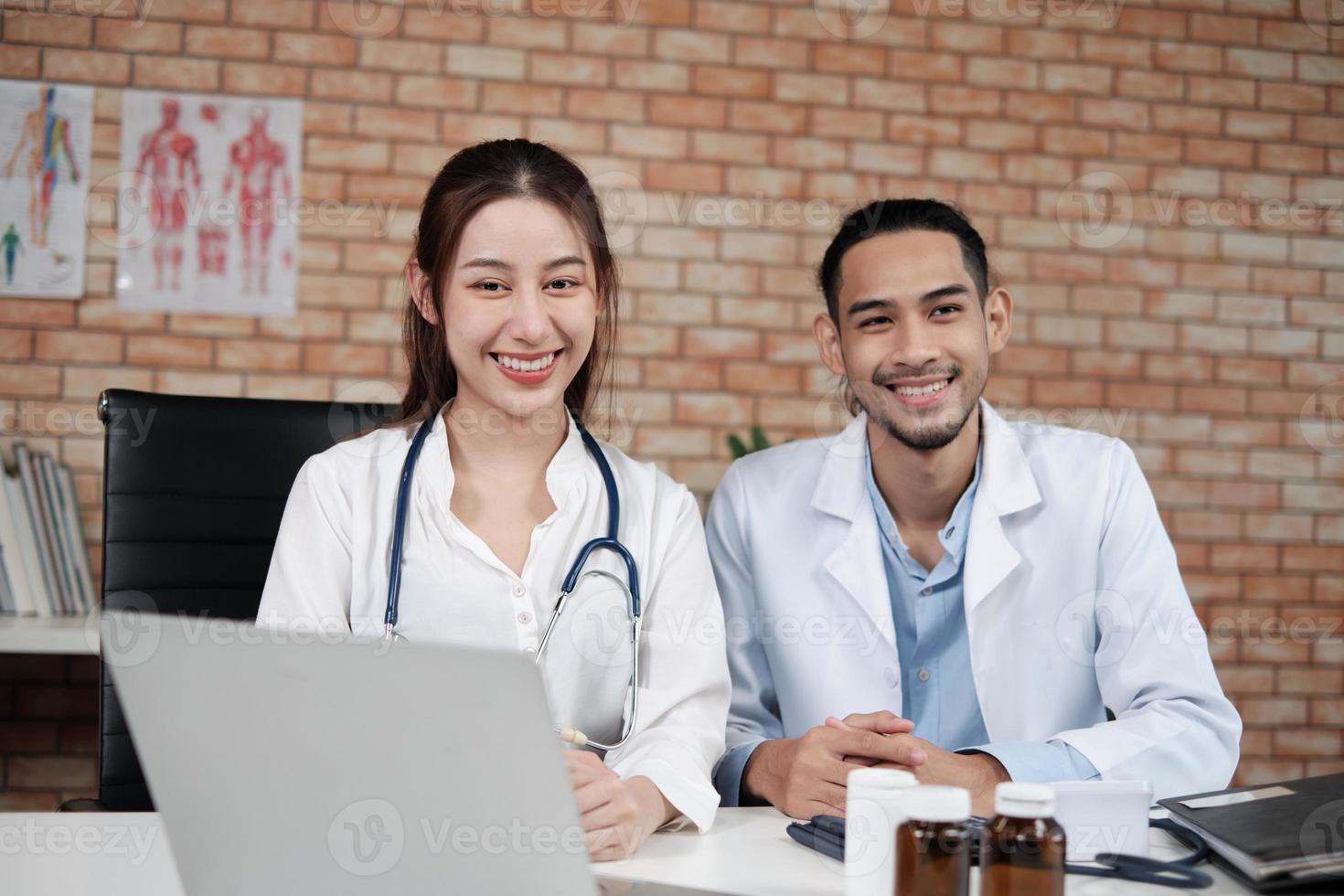 vårdpartners team, porträtt av två unga läkare av asiatisk etnicitet i vita skjortor med stetoskop, leende och titta på kameran i kliniken, personer som har expertis inom professionell behandling. foto