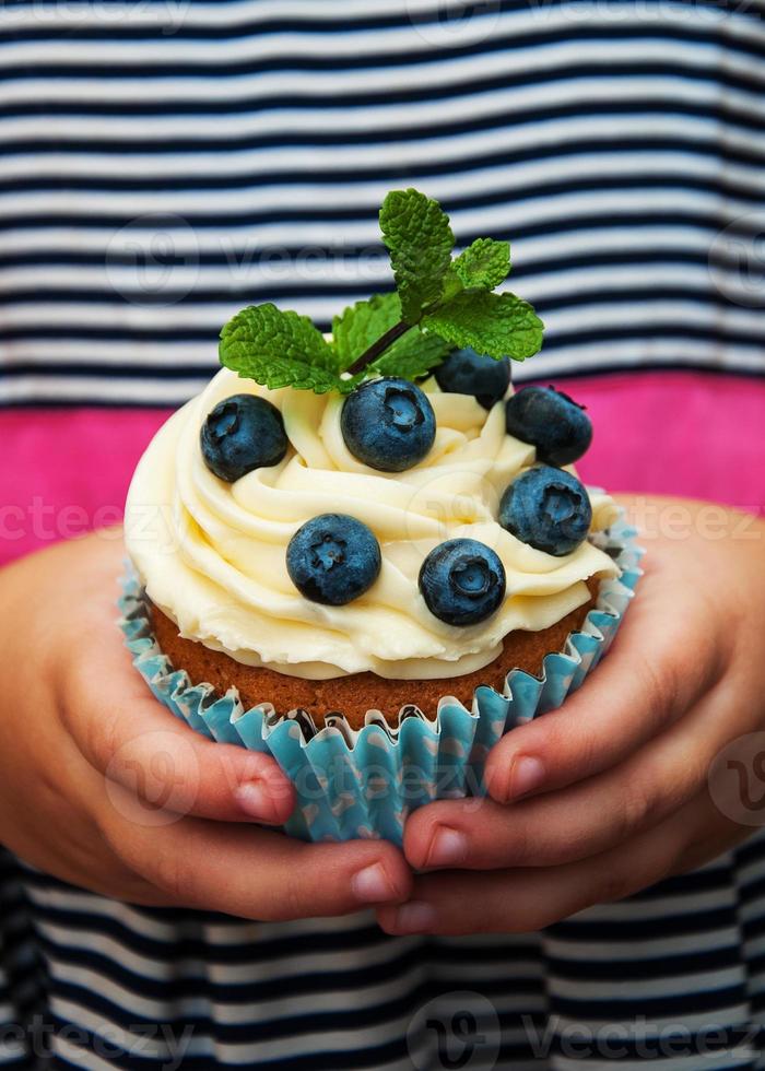 liten flicka håller cupcake foto