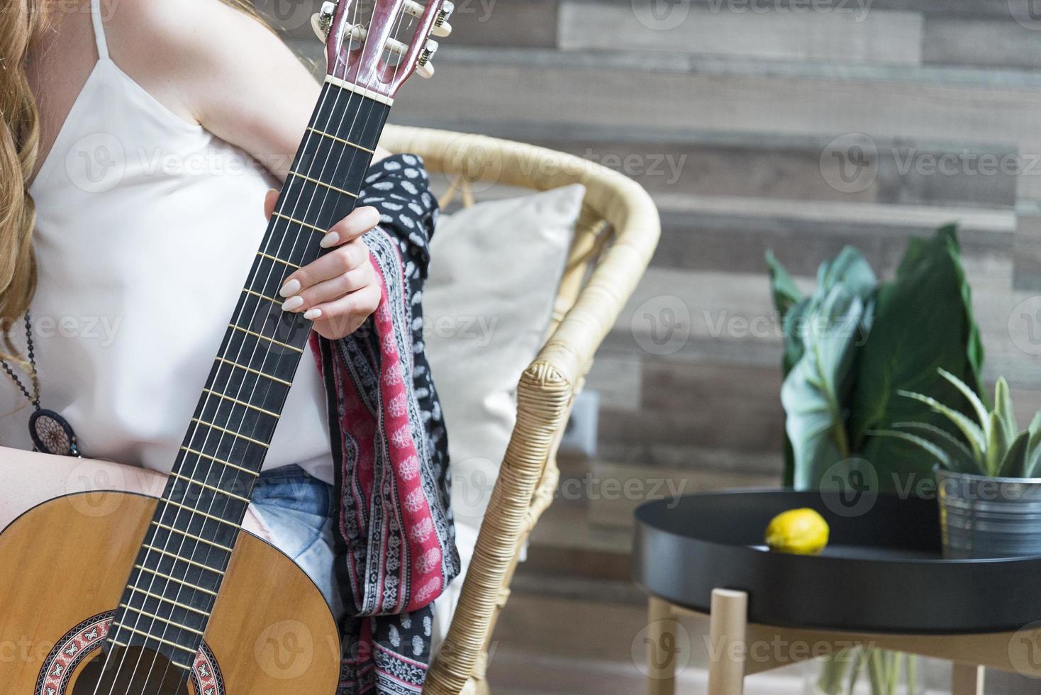 kvinnlig malm håller en sju-strängad klassisk gitarr. foto