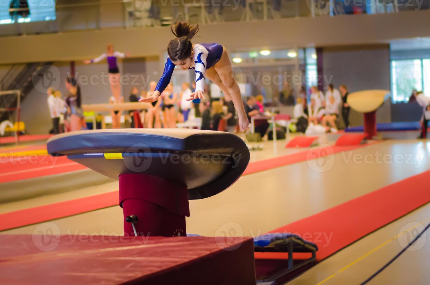 ung gymnast flicka utför hopp foto