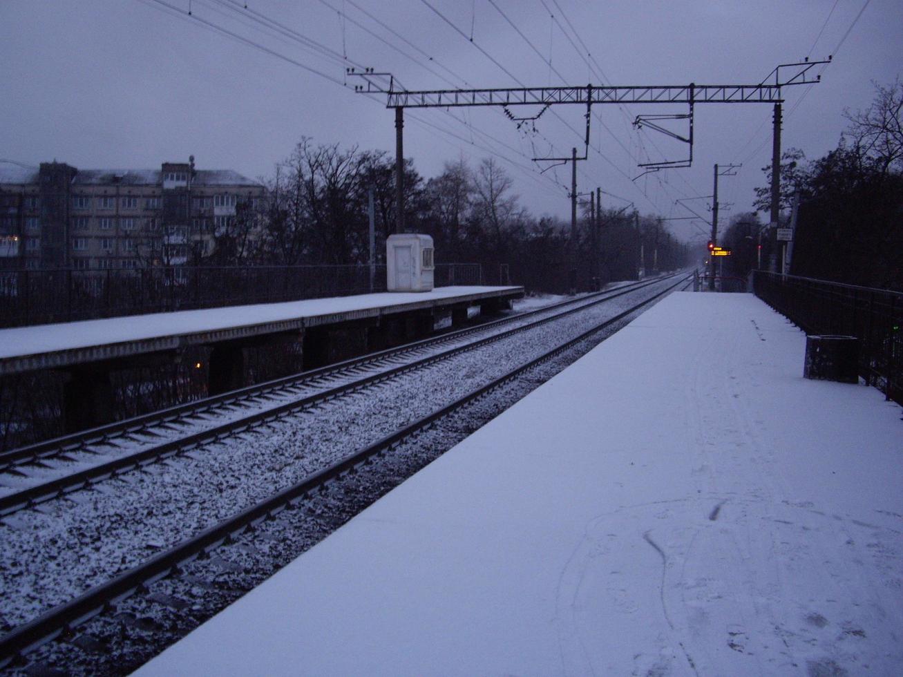 snötäckt järnvägsplattform på morgonen på vintern foto