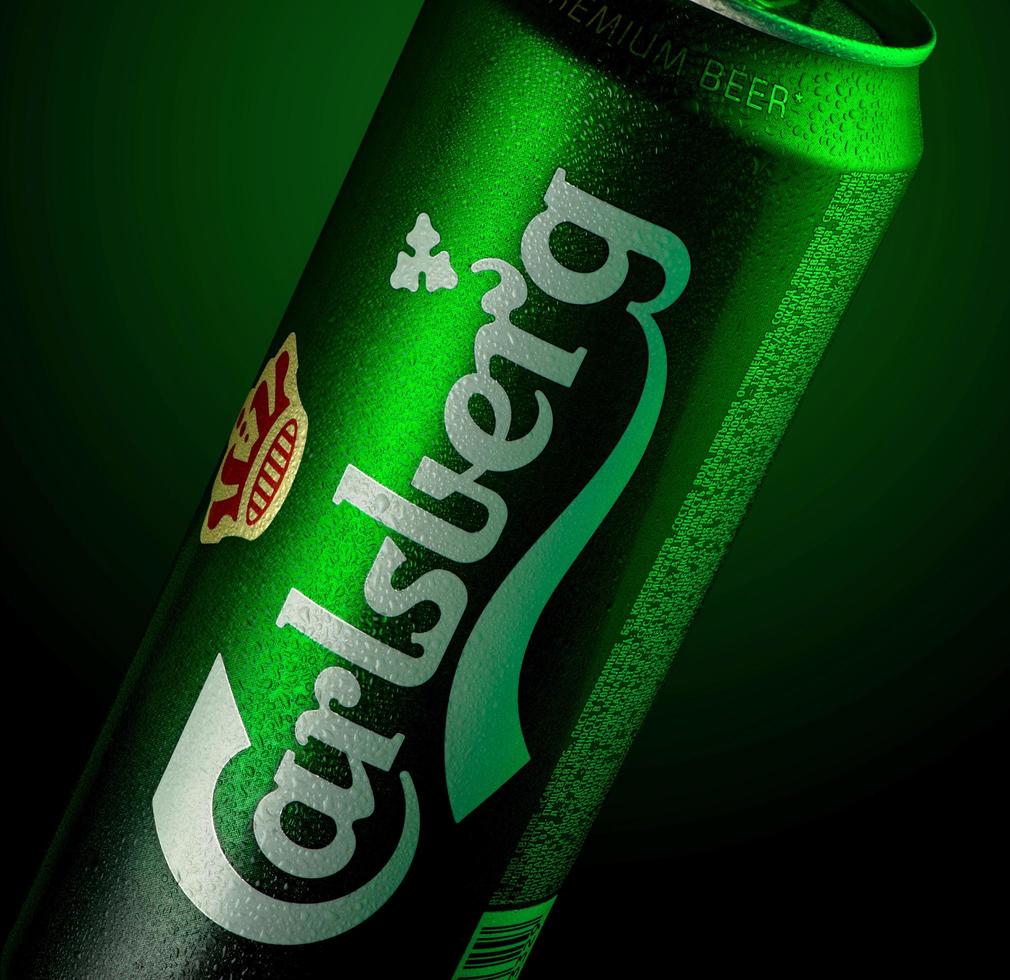 almaty, kazakstan 11 oktober 2019 burk öl carlsberg i en grön bakgrund med belysning. reklam för ett ölmärke foto