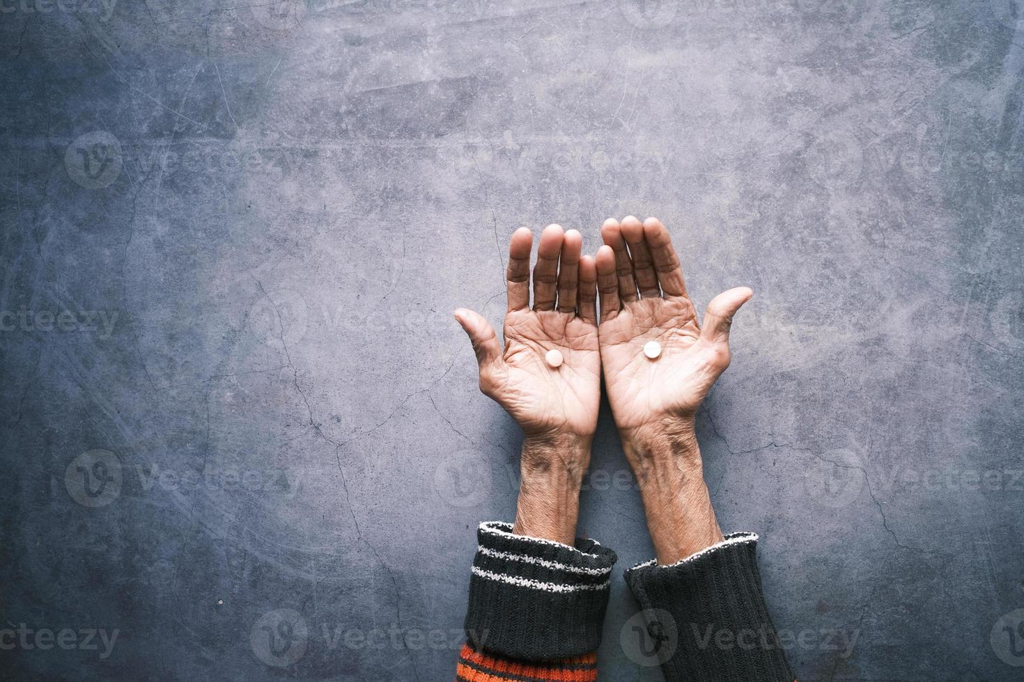 ovanifrån av piller och kapsel på äldre kvinnors hand på ryggen bakgrund foto