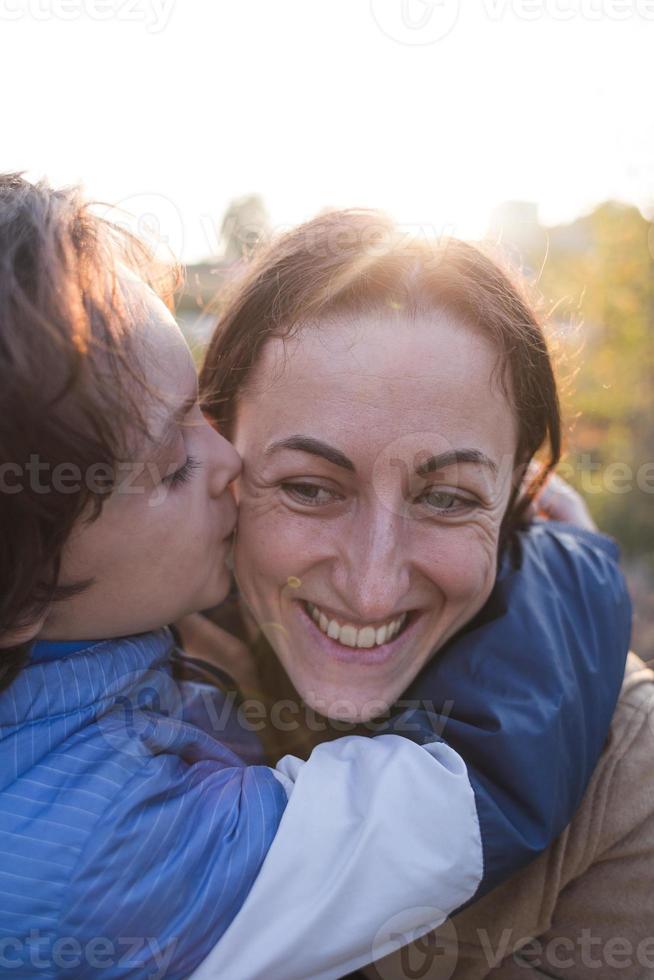 pojke pussar och kramar mamma, lyckligt moderskap foto