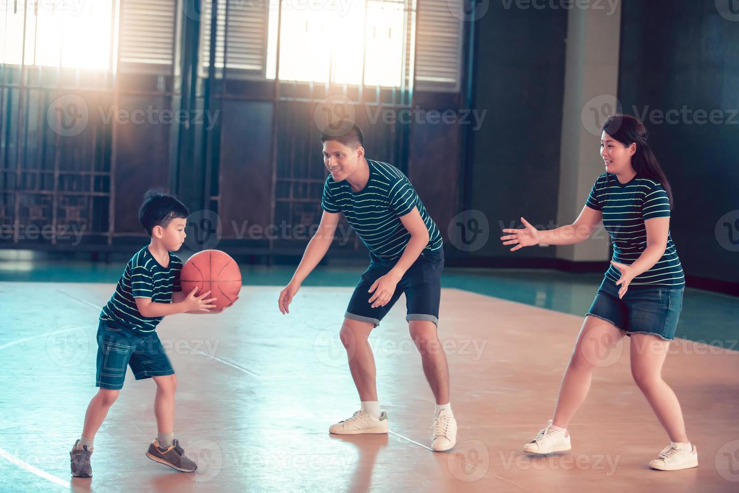 asiatisk familj som spelar basket tillsammans. lycklig familj som spenderar ledig tid tillsammans på semester foto
