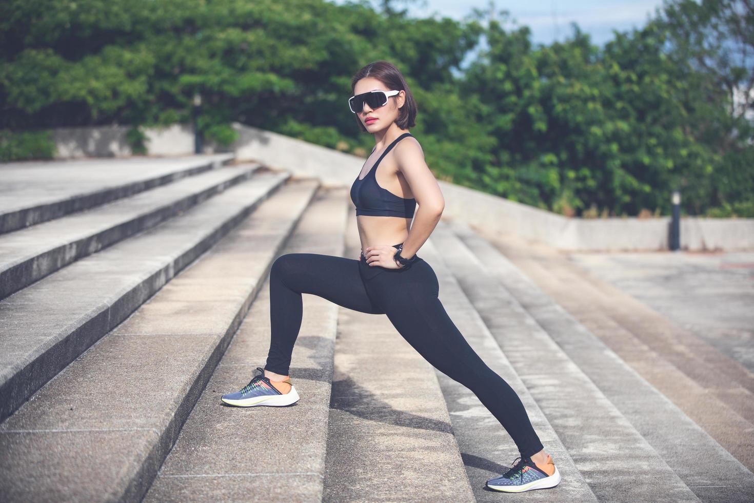 atletisk kvinna asiatisk uppvärmning och ung kvinnlig idrottare sitter på en träning och stretching i en park innan löpare utomhus, hälsosamt livsstilskoncept foto