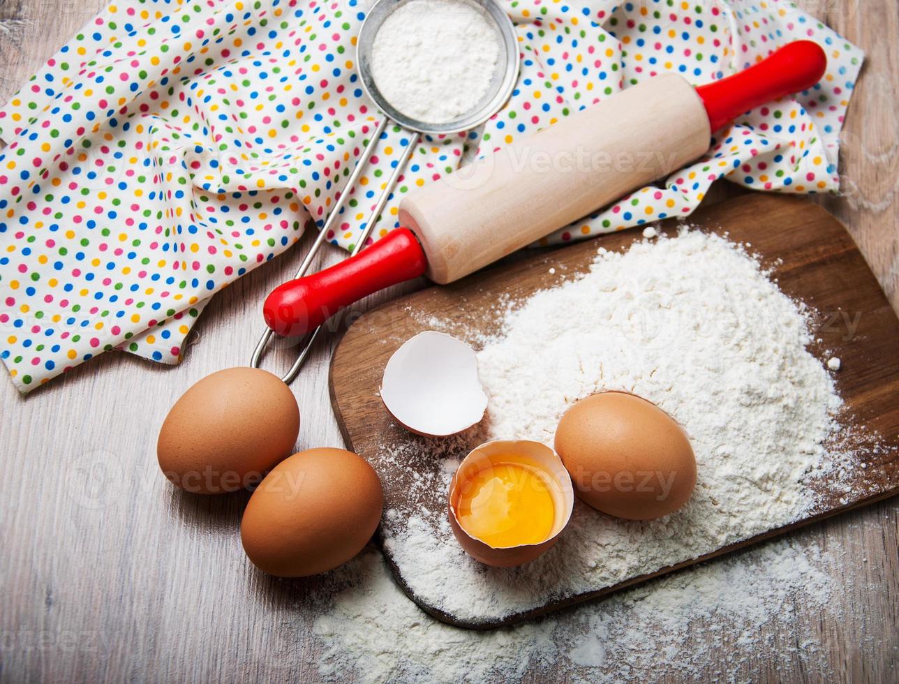 bakningsingredienser - mjöl, ägg och nål foto
