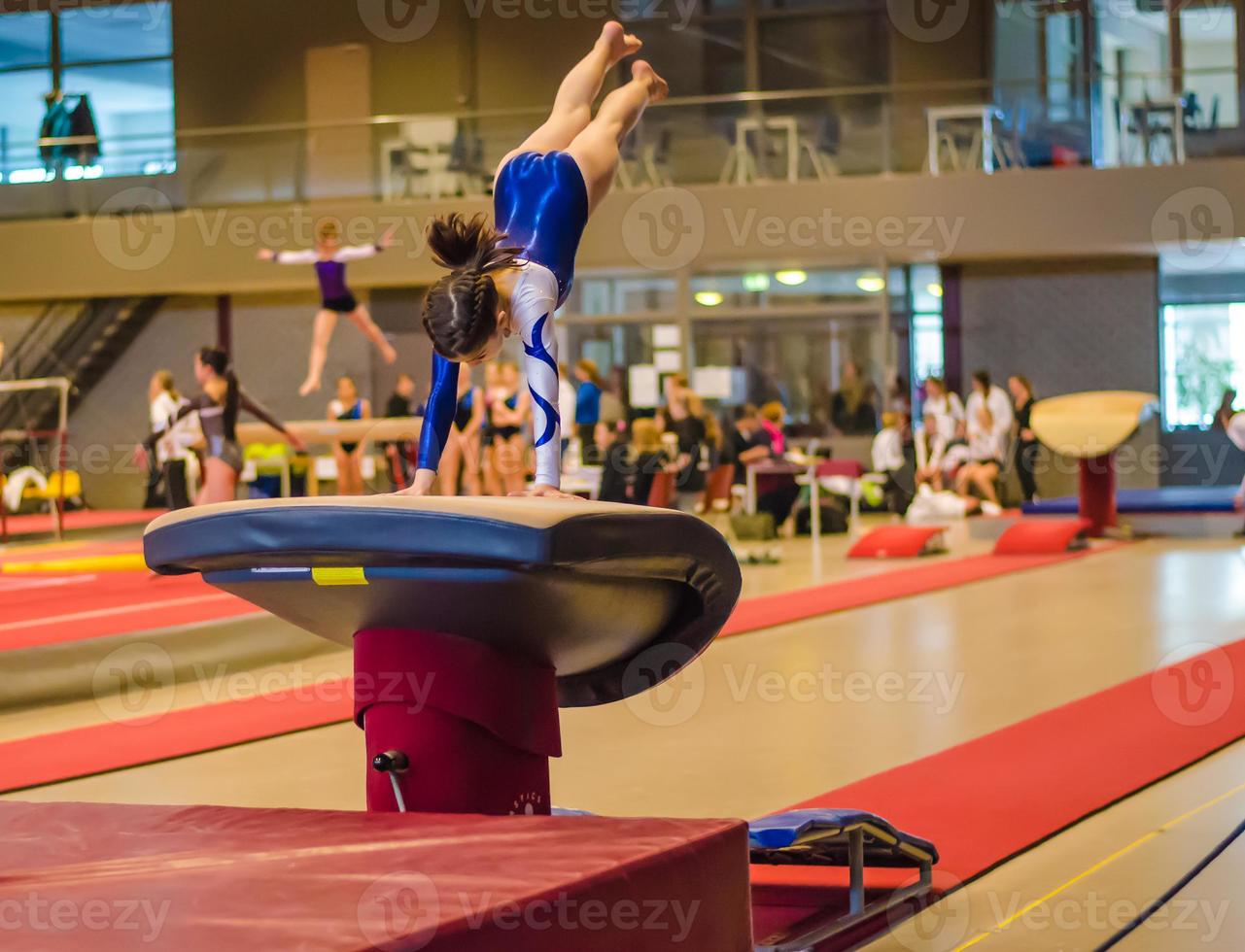 ung gymnast flicka utför hopp foto