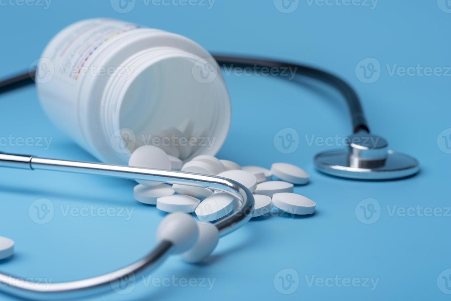 medicin stetoskop och piller på blå bakgrund. hälsa eller sjukdom. foto