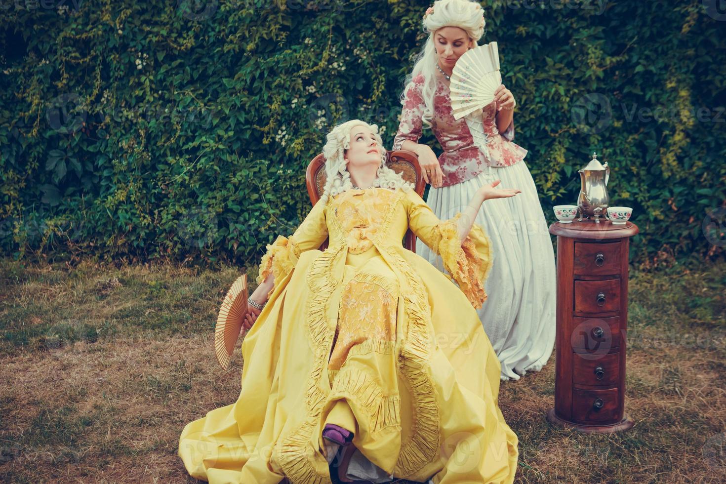 porträtt av två blonda kvinnor klädda i historiska barockkläder foto