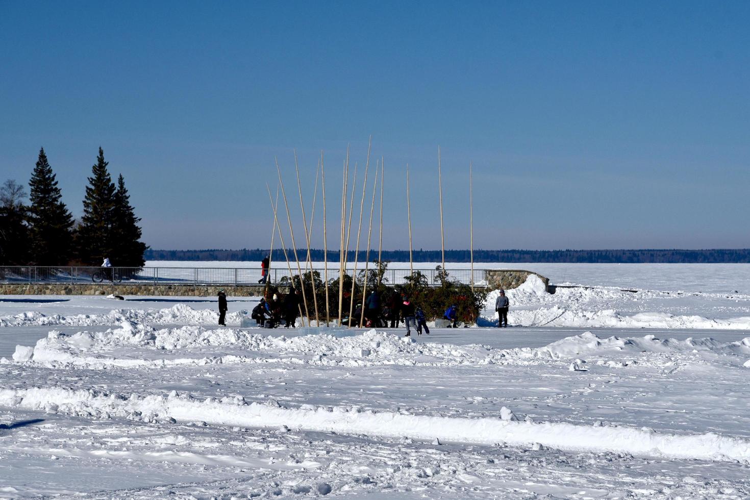 vinter i Manitoba - skridskoåkare värmer upp på sjön foto