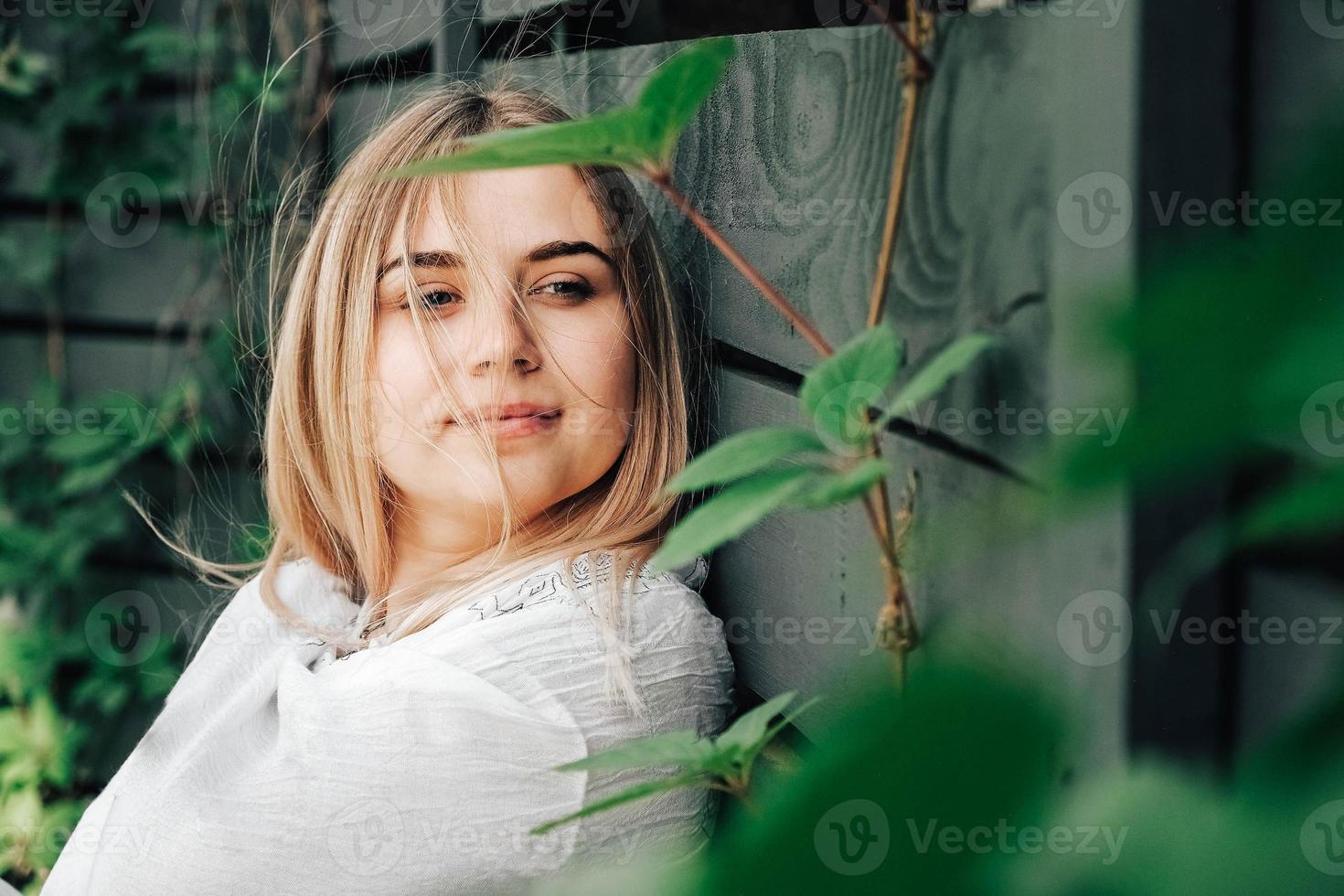 porträtt av en vacker blond tjej med naturlig skönhet i gröna löv träd. kopiera, tomt utrymme för text foto