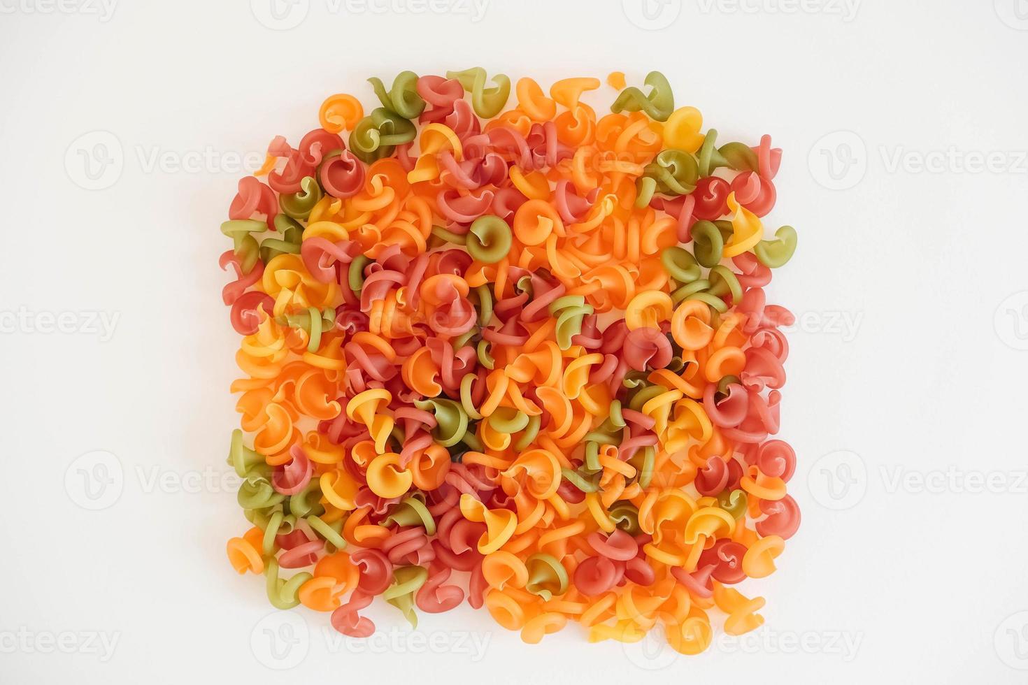 mångfärgad pasta utspridda på en vit bakgrund. toppvy. kopiera, tomt utrymme för text foto