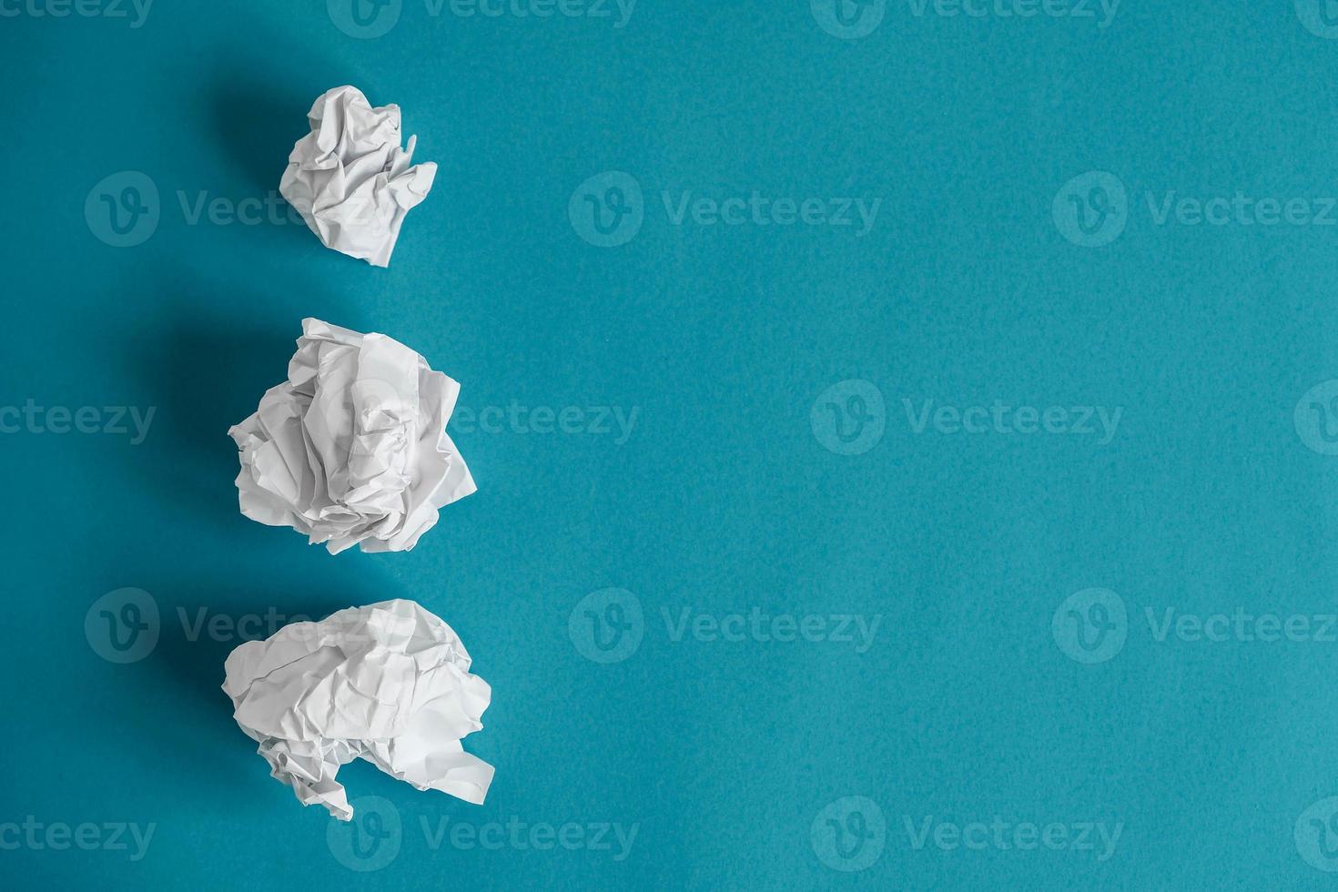 skrynkliga pappersbollar på en blå bakgrund. minimalistiskt koncept. toppvy. kopiera, tomt utrymme för text foto