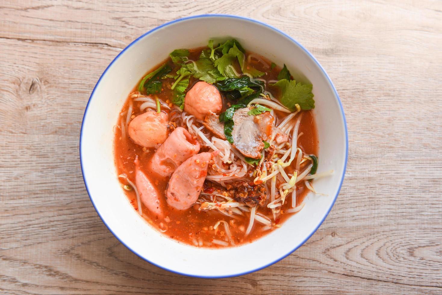 röd soppa nudelfläsk med rött rostat fläsk och böngroddargrönsak i soppskål på träbord, ovanifrån thailändsk och kinesisk mat foto