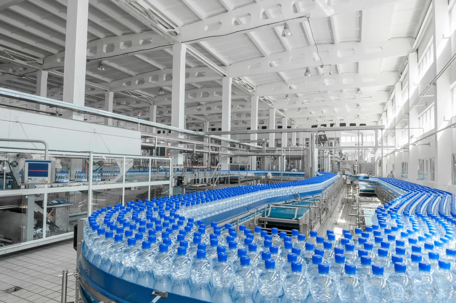 tashkent, uzbekistan - 7 juni 2016 - anläggning för tillverkning av plastflaskor. plastflaskor på ett löpande band. påfyllning av vatten på flaska foto