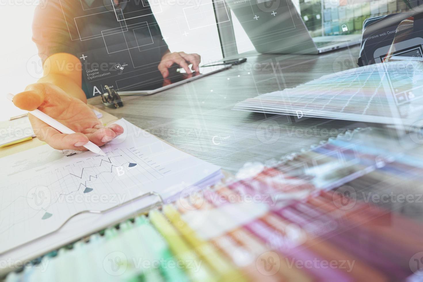 två kollegor inredare diskuterar data och digital surfplatta och dator bärbar dator med provmaterial och digitalt designdiagram på träskrivbord som koncept foto