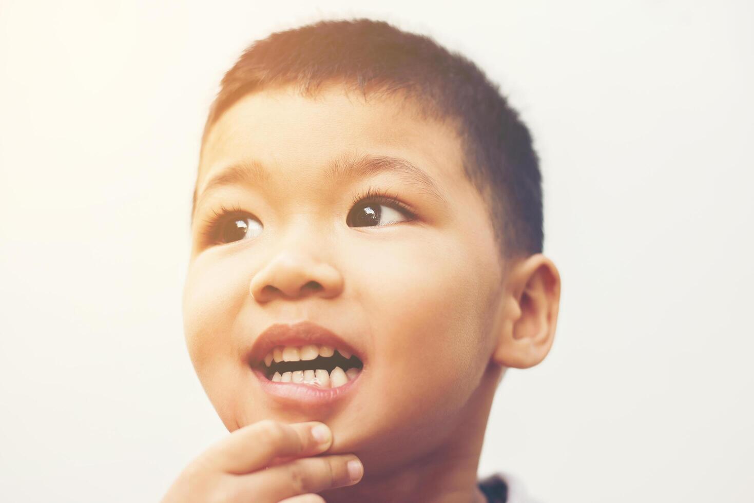 glad pojke skratt tittar på kamera porträtt med isolera vit bakgrund. foto