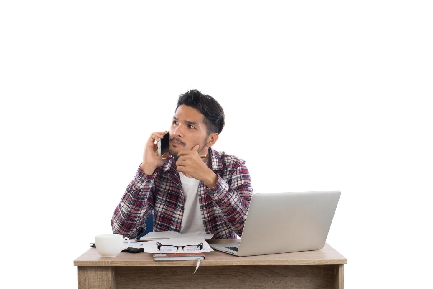 affärsman pratar i telefon medan han arbetar med laptop på kontoret isolerad på vit bakgrund. foto