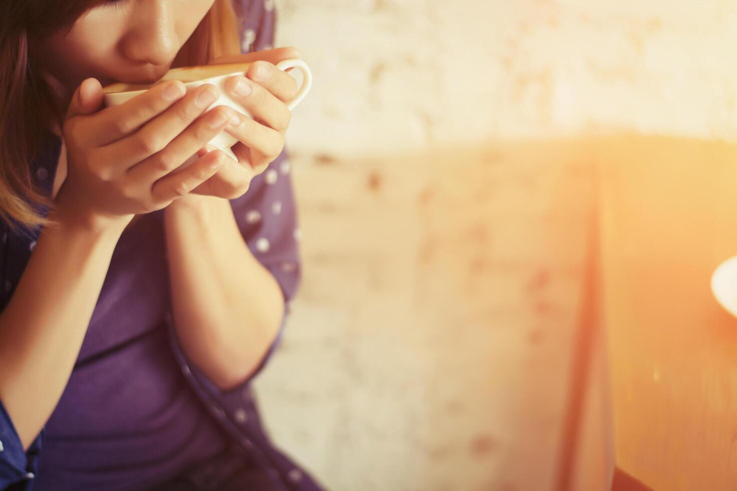 vackra kvinnor med en kopp kaffe på vit tegelvägg bakgrund foto